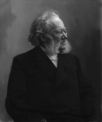 A photo of Henrik Ibsen looking left, in a distinguished dark suit with incredible flowing gray sideburns or muttonchop whiskers