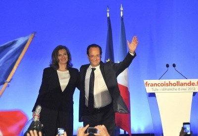 A photo of Francois Hollande and his girlfriend, Valerie Trierweiler, smiling and waving to supporters in a political hall