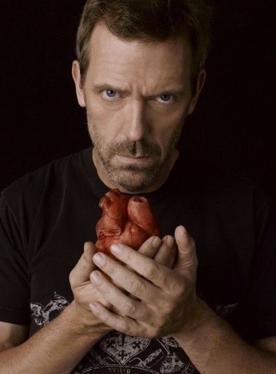 Photo of Hugh Laurie as Dr. House, holding a red human heart in his hands