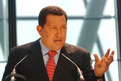 Photo of Hugo Chavez at a podium, speaking while gesticulating with his left hand