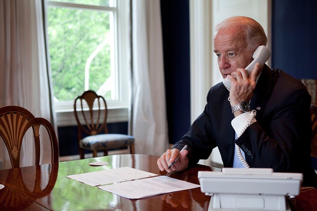 Photo of Joe Biden talking on the phone at an elegant White House desk