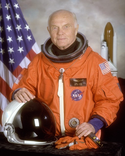 Photo of John Glenn in a bright orange shuttle space suit