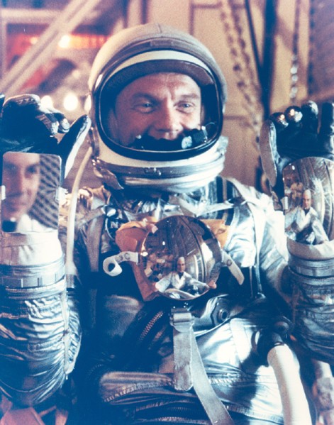 Photo of John Glenn in a silver space suit, ready for launch