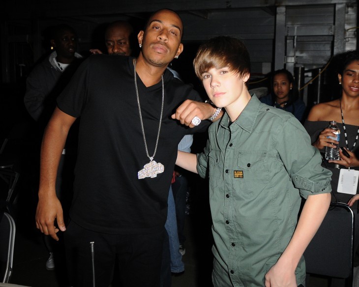 Photo of Justin Bieber smiling just slightly with an arm around Ludacris