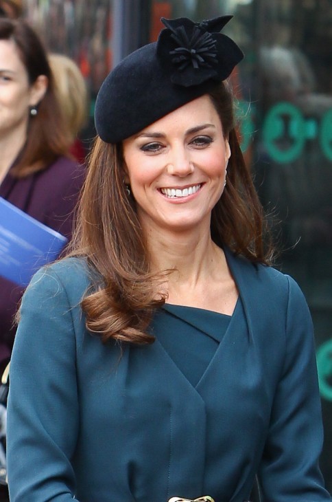 Photo of Kate Middleton in stylish black hat and green wraparound sweater