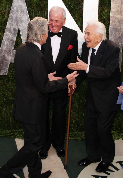 Photo of Kirk Douglas beaming as he greets his son, both in tuxedos