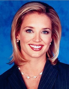 A photo of Laurie Dhue, smiling, in a blue pinstriped suit with short blonde hair and a pearl necklace