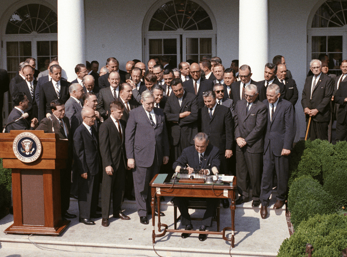 LBU signs the Poverty Bill in May of 1964 as members of Congress look on. Photo by Cecil Stoughton, courtesy of the LBJ Library.