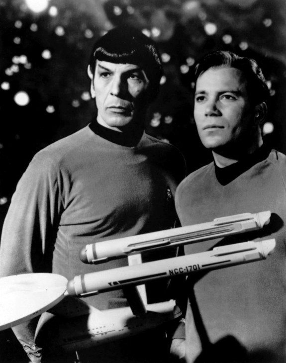 Photo of Leonard Nimoy and William Shatner, as Spock and Kirk, standing with a model of the USS Enterprise