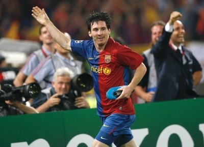 Lionel Messi photo with him running with hand upraised and holding a blue shoe