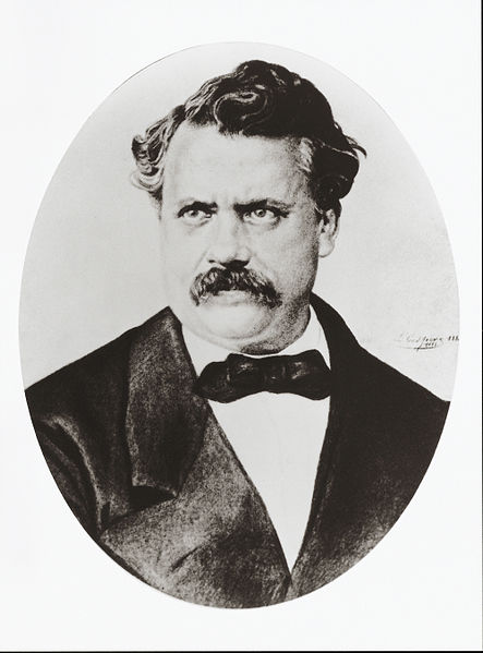 A photo of Louis Vuitton with a graying moustache, old-fashioned black suit and formal bow tie, and brushy hair