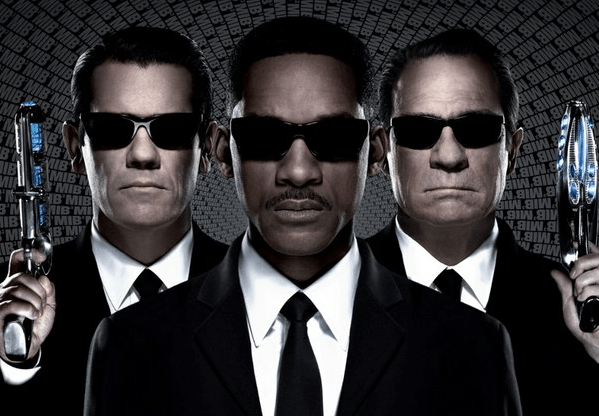 Men In Black 3 photo of three men in black suits and black sunglasses, two holding alien space guns