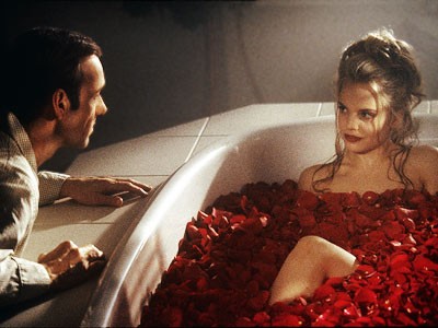 Photo of Kevin Spacey looking at Mena Suvari in a bathtub full of rose petals