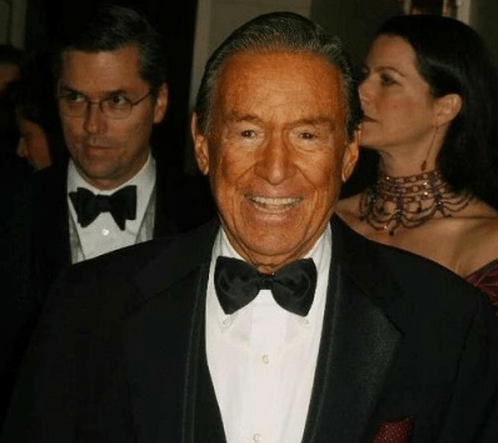 Photo of Mike Wallace, smiling, in a tuxedo at some kind of formal event