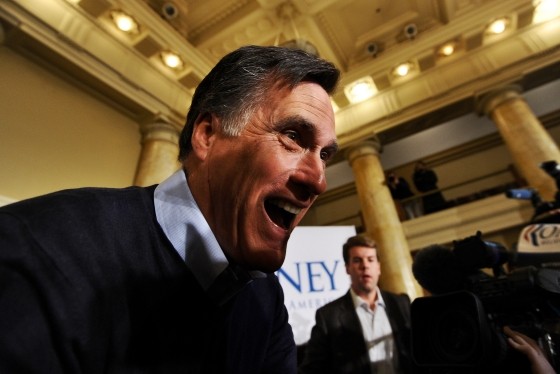 Mitt Romney guffaws as he leans towards his audience at a campaign rally