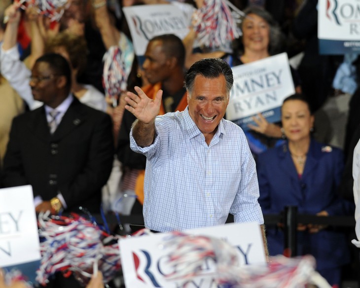 Photo of Mitt Romney at a campaign rally, surrounded by signs