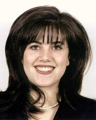 A photo of Monica Lewinsky, smiling, in a blue suit and pearls