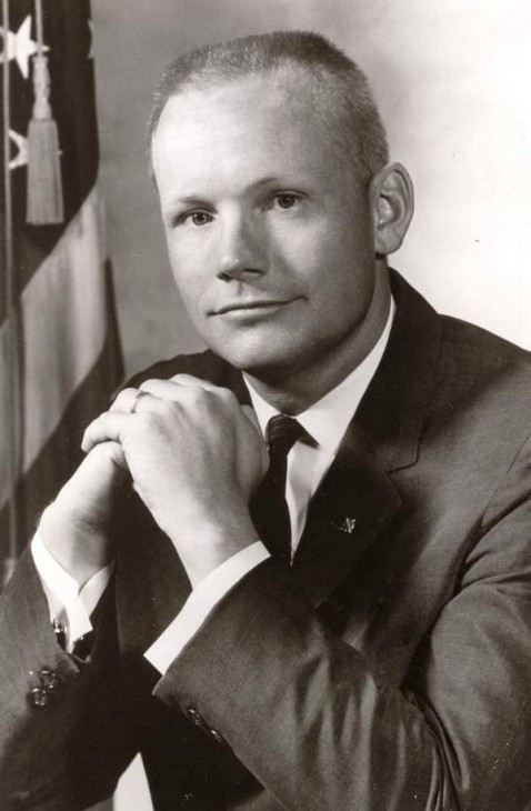 Photo of a young Neil Armstrong with a brush-cut and the US flag