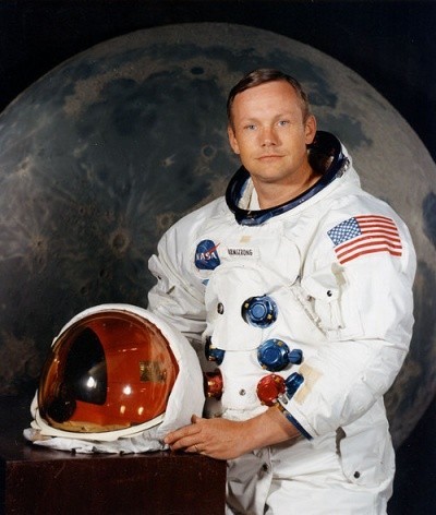 Neil Amrstrong poses in his space suit, smiling calmly for camera