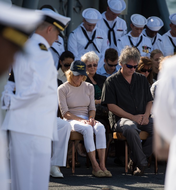 A photo of Neil Armstrong's wife and his son, sitting on deck with heads bowed