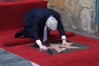 Randy Newman bows over his Hollywood star
