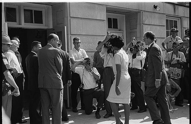 A balding Nicholas Katzenbach looks on as a black student enters the doors of the University of Alabama