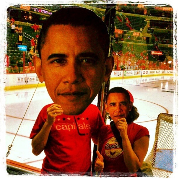 Fans hold up giant photos of Barack Obama's head in front of the hockey rink