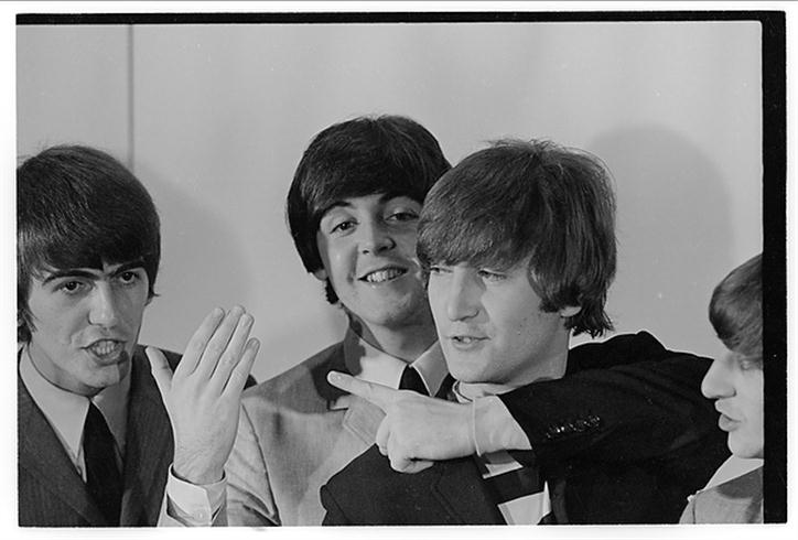 A photo of the Beatles, having fun, McCartney with his arm around Lennon's neck