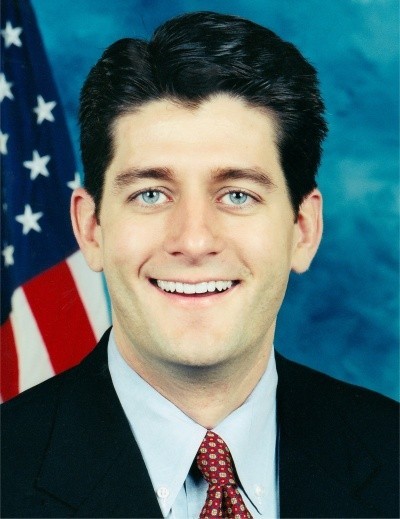 A photo of Paul Ryan smiling in a blue suit in front of an American flag