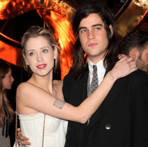 Peaches Geldof on the red carpet, with her arm draped across her husband's front