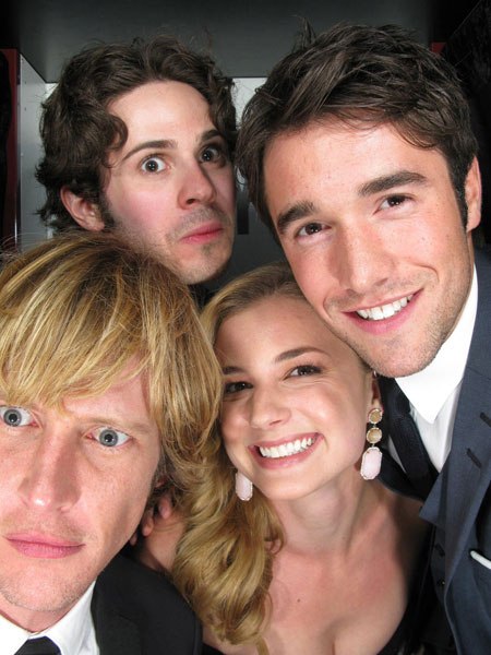 Four handsome young actor types pose together in a photo booth