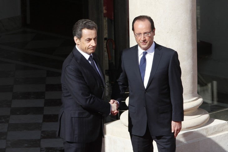 Photo of Nicholas Sarkozy and Francois Hollande, obviously shaking hands for the cameras in a frozen pose