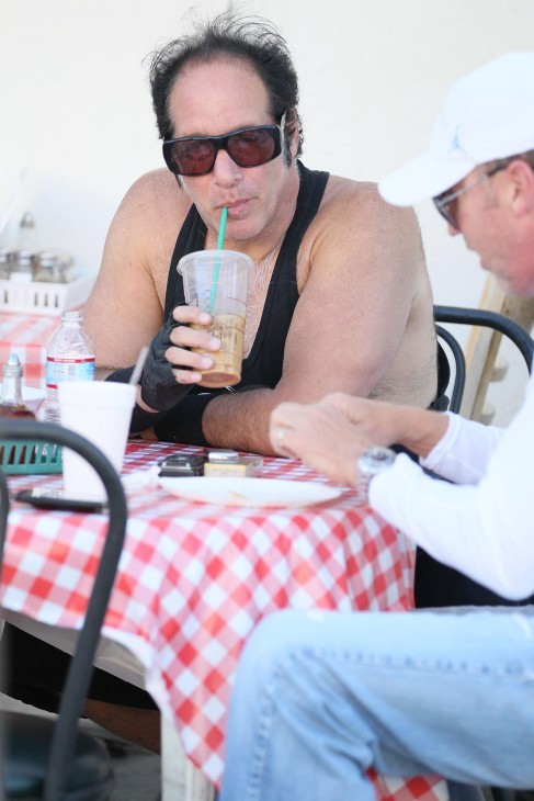 Photo of Andrew Dice Clay, looking pudgy and balding, in a t-shirt and slurping an iced coffee through a straw