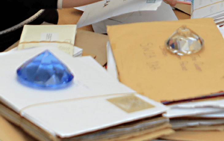 Photo of two huge jewels (like, six inches across) holding down stacks of paper