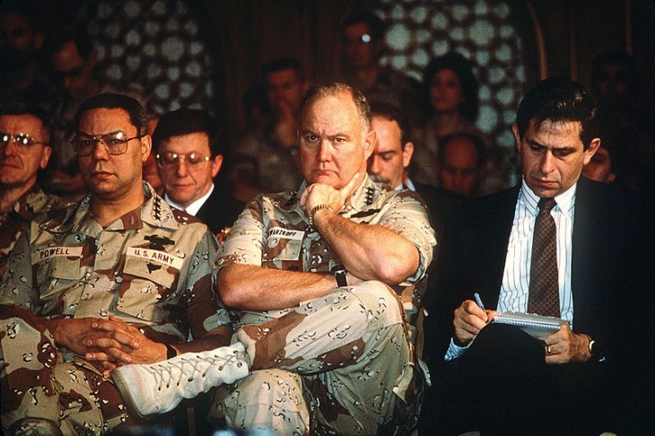 A photo of army officers in camouflage, sitting in a press conference