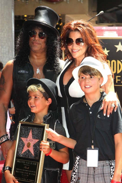 Photo of Slash with his wife (or girlfriend, anyway) and two boys who look remarkably clean-cut and smiley in sans-a-belt slacks