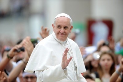 A photo of Pope Francis I, in white robes, among an outdoor crowd