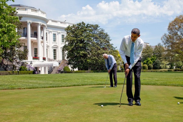Photo of Barack Obama and Joe Biden putting on a green with the White House in the background