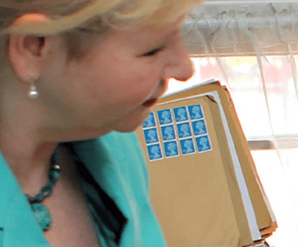 Photo of an envelope covered with stamps bearing the face of the Queen of England