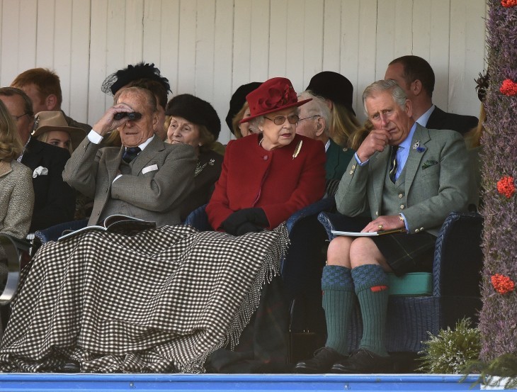Queen Elizabeth and Prince Philip sit under a blanket at the Highland Games
