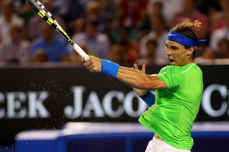 Rafael Nadal grimaces as he whacks a forehand with a muscular left arm