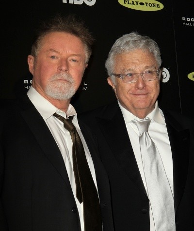 Photo of two older men in nice black suits standing side by side