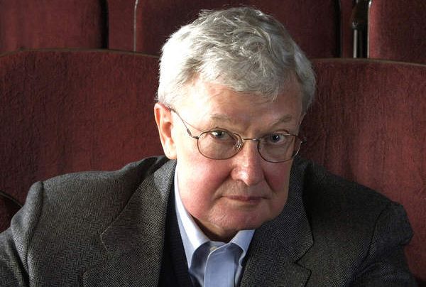 Roger Ebert photo, looking stern while sitting in red velvet movie chair