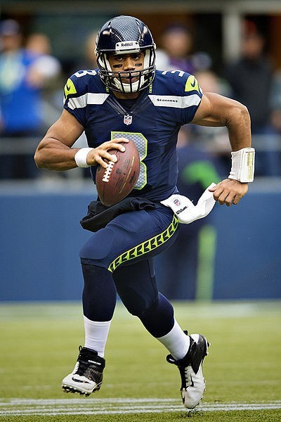 Photo of Russell Wilson sprinting across the field in a Seattle Seahawks uniform