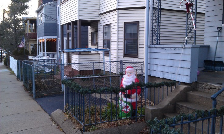 Photo of Santa Claus statue in a yard surrouded by sidewalk and space
