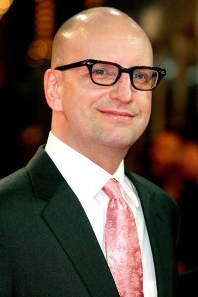 A photo of Stephen Soderbergh, bald and smiling with a pink tie, at a film festival