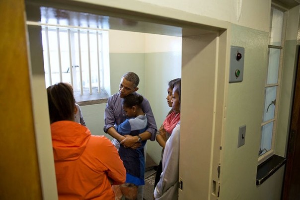 Barack Obama hugs his daughter Sasha as they visited the prison at Robben Island in South Africa. Official White House photo.