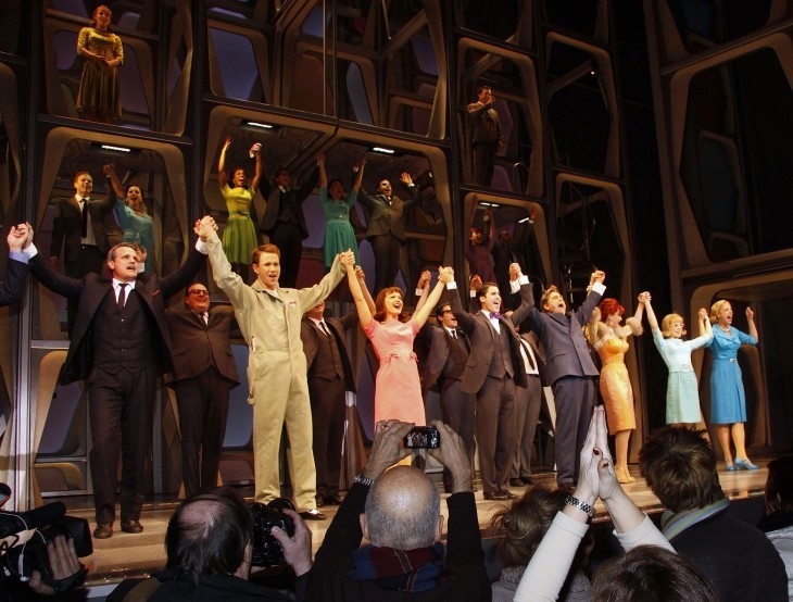 Photo of an audience giving a standing ovation to a cast taking its bows at the curtain call