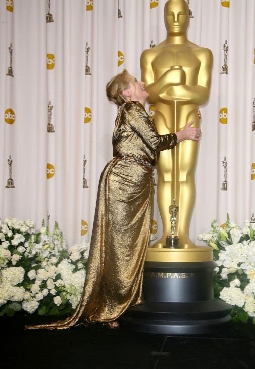 Photo of Meryl Streep hugging a huge statue of Oscar