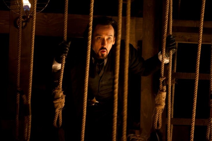 A photo of John Cusack as Edgar Allan Poe, looking through stage ropes backstage at some kind of play